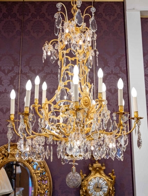 Lustre en bronze doré à 16 bras de lumière et 12 fleurettes en cristal éclairées, XIXème siècle||||||||||