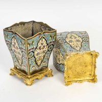 Élégante paire de cache-pots en cloisonné et bronze à patine dorée, datant de la seconde moitié du XIXe siècle. Ils reposent chacun sur un petit socle auquel, ils sont vissés. 