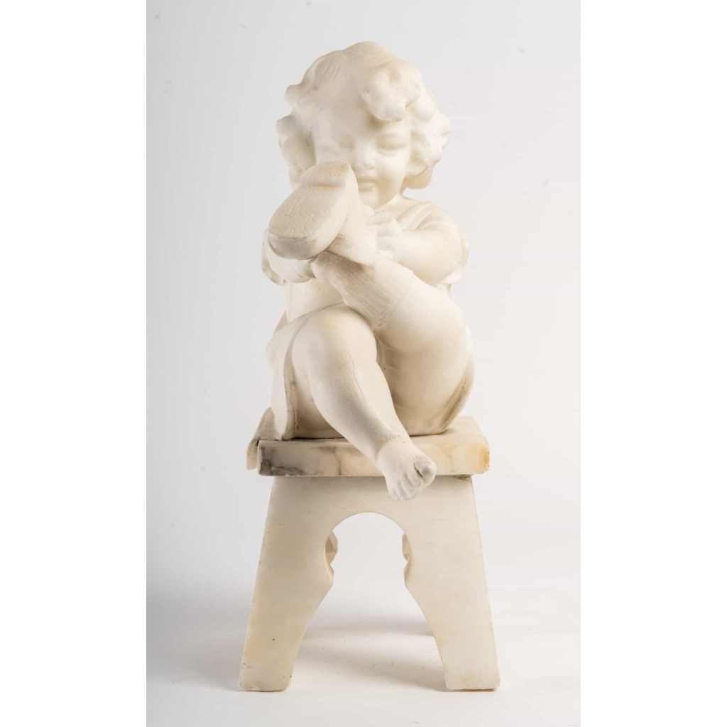 Statue en albâtre représentant une petite fille assise sur un tabouret et jouant avec des chaussures . ||||||||