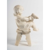 Statue en albâtre représentant une petite fille assise sur un tabouret et jouant avec des chaussures . Statue en albâtre représentant une petite fille assise sur un tabouret et jouant avec des chaussures .