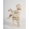 Statue en albâtre représentant une petite fille assise sur un tabouret et jouant avec des chaussures . Statue en albâtre représentant une petite fille assise sur un tabouret et jouant avec des chaussures .