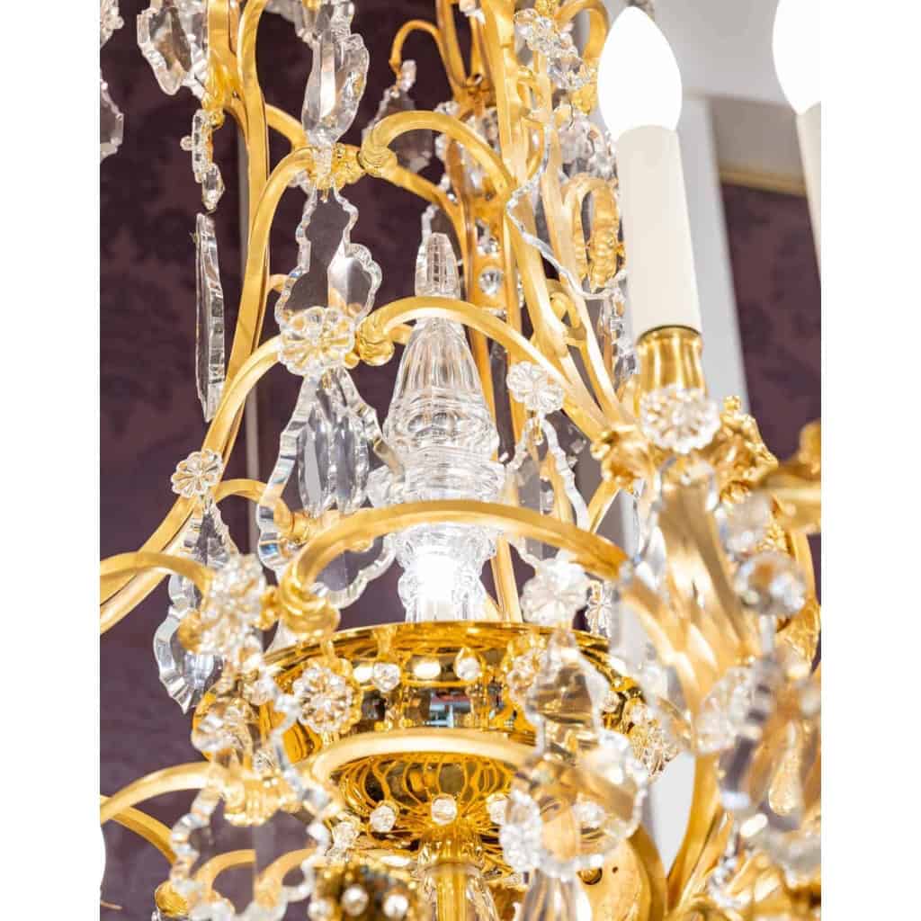 Lustre en bronze doré à 16 bras de lumière et 12 fleurettes en cristal éclairées, XIXème siècle Lustre en bronze doré à 16 bras de lumière et 12 fleurettes en cristal éclairées, XIXème siècle