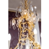 Lustre en bronze doré à 16 bras de lumière et 12 fleurettes en cristal éclairées, XIXème siècle Lustre en bronze doré à 16 bras de lumière et 12 fleurettes en cristal éclairées, XIXème siècle