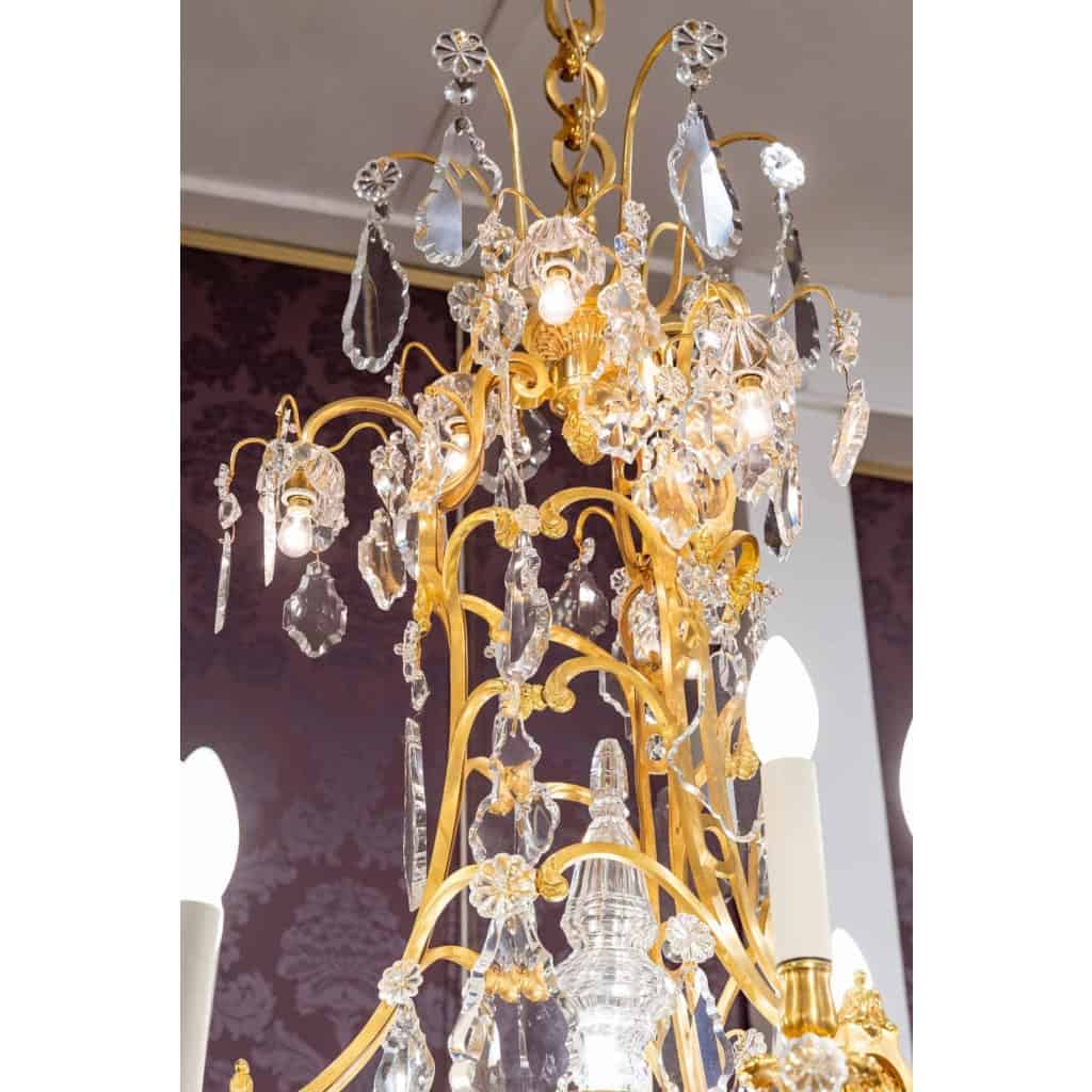 Lustre en bronze doré à 16 bras de lumière et 12 fleurettes en cristal éclairées, XIXème siècle Lustre en bronze doré à 16 bras de lumière et 12 fleurettes en cristal éclairées, XIXème siècle