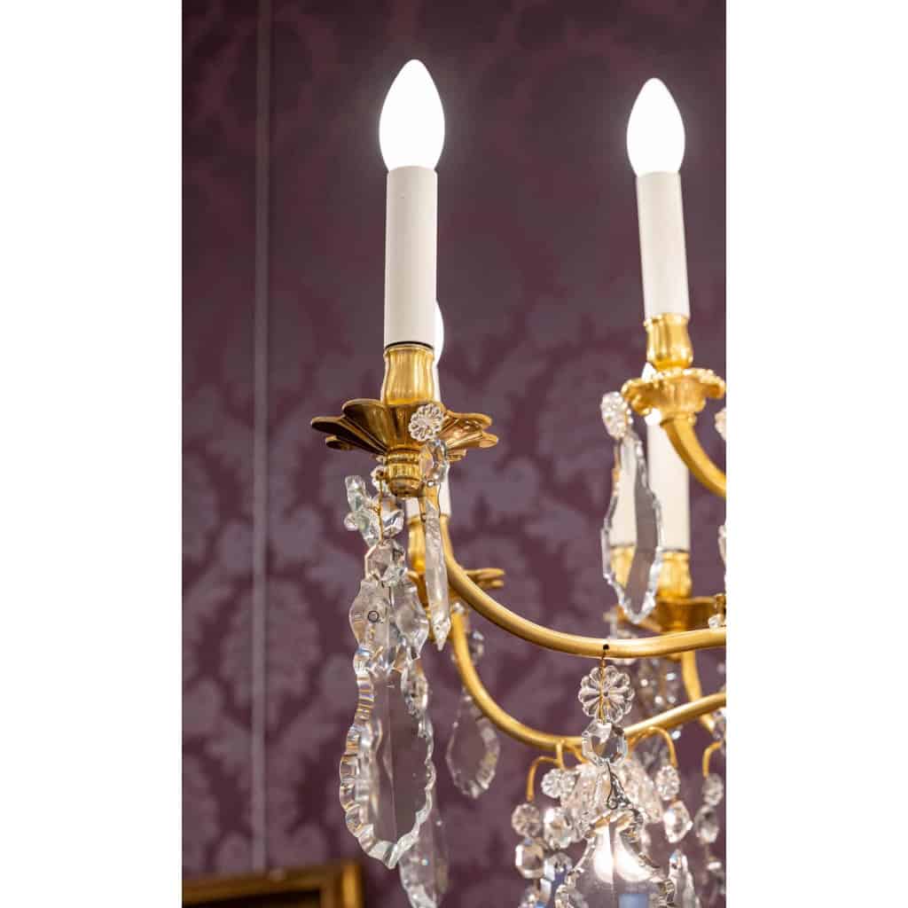 Lustre en bronze doré à 16 bras de lumière et 12 fleurettes en cristal éclairées, XIXème siècle Lustre en bronze doré à 16 bras de lumière et 12 fleurettes en cristal éclairées, XIXème siècle