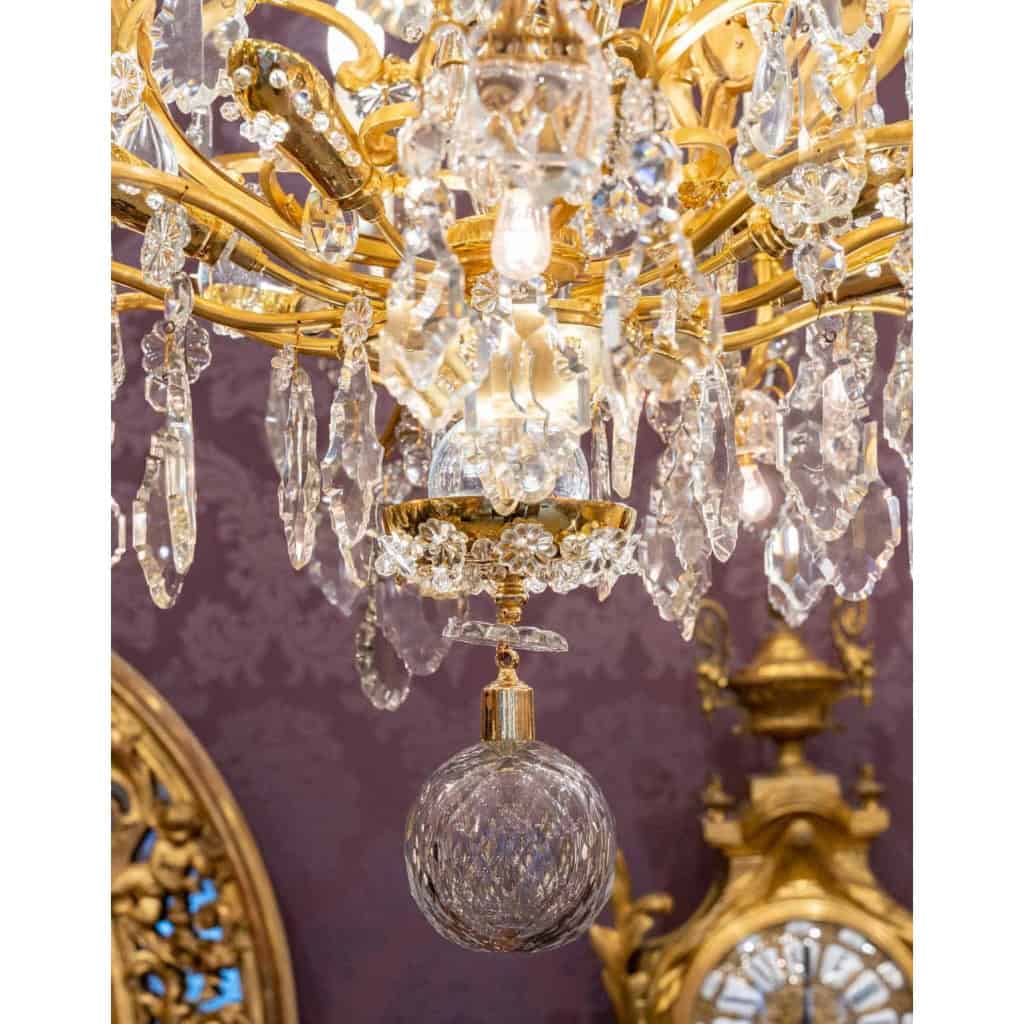 Lustre en bronze doré à 16 bras de lumière et 12 fleurettes en cristal éclairées, XIXème siècle Lustre en bronze doré à 16 bras de lumière et 12 fleurettes en cristal éclairées, XIXème siècle