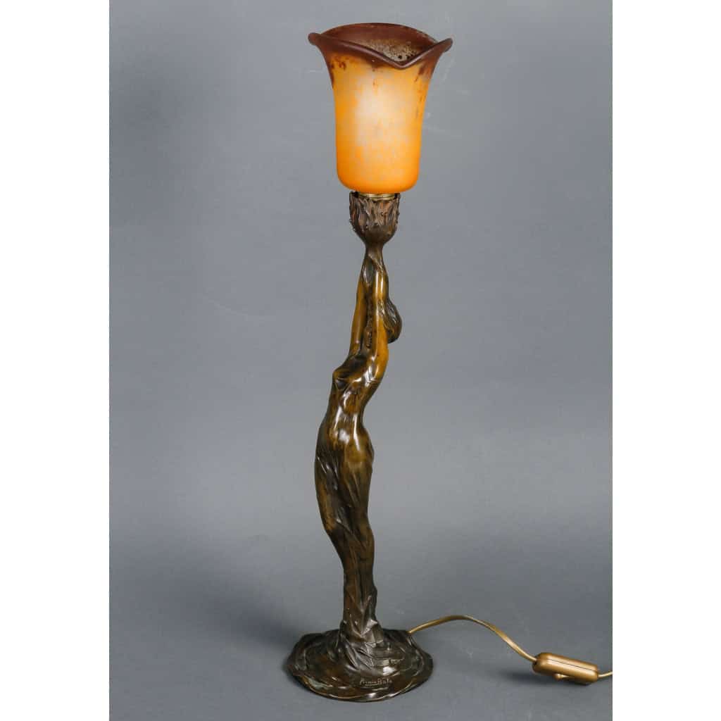 Lampe en bronze patiné représentant une femme retenant une tulipe en pâte de verre. Époque Art Nouveau vers 1900. Signée Firmin Bate ||||||||||