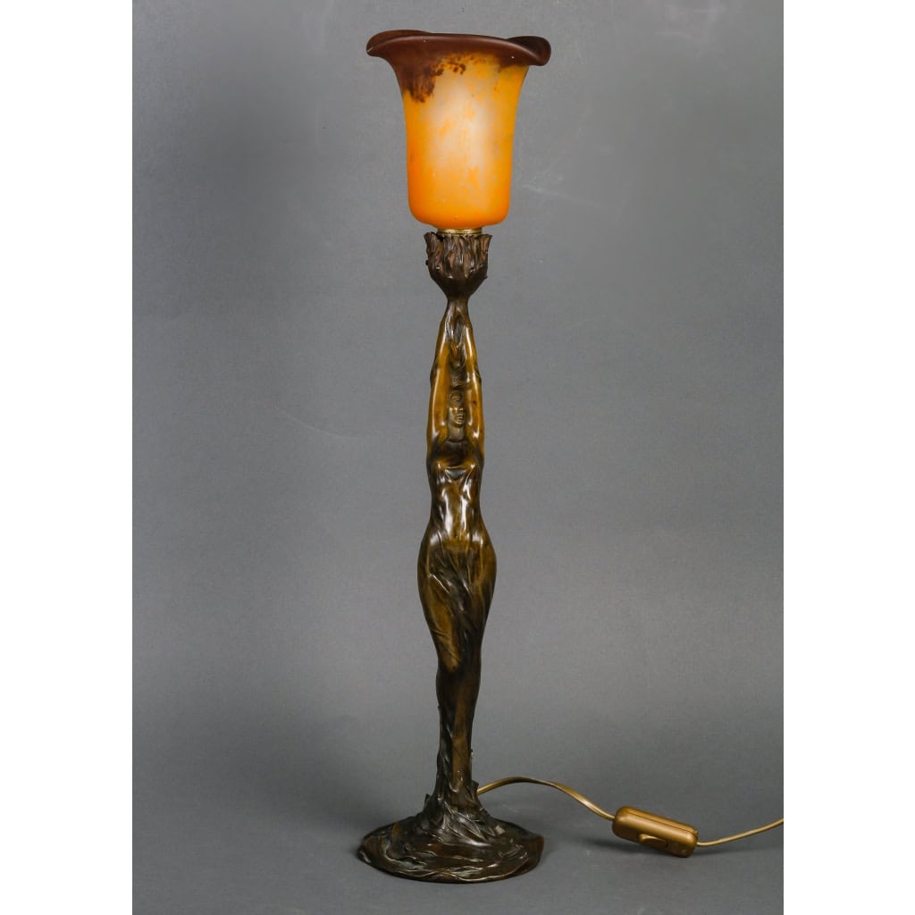 Lampe en bronze patiné représentant une femme retenant une tulipe en pâte de verre. Époque Art Nouveau vers 1900. Signée Firmin Bate Lampe en bronze patiné représentant une femme retenant une tulipe en pâte de verre. Époque Art Nouveau vers 1900. Signée Firmin Bate