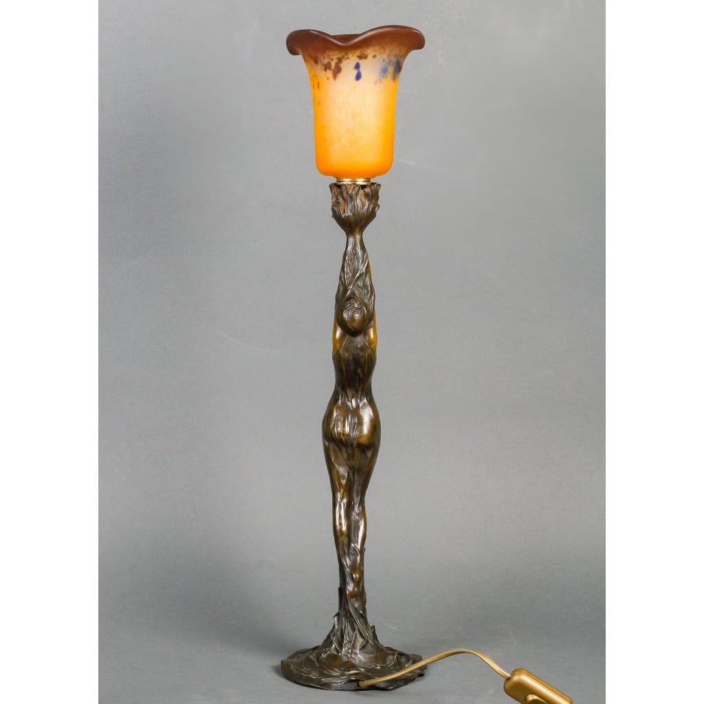 Lampe en bronze patiné représentant une femme retenant une tulipe en pâte de verre. Époque Art Nouveau vers 1900. Signée Firmin Bate Lampe en bronze patiné représentant une femme retenant une tulipe en pâte de verre. Époque Art Nouveau vers 1900. Signée Firmin Bate