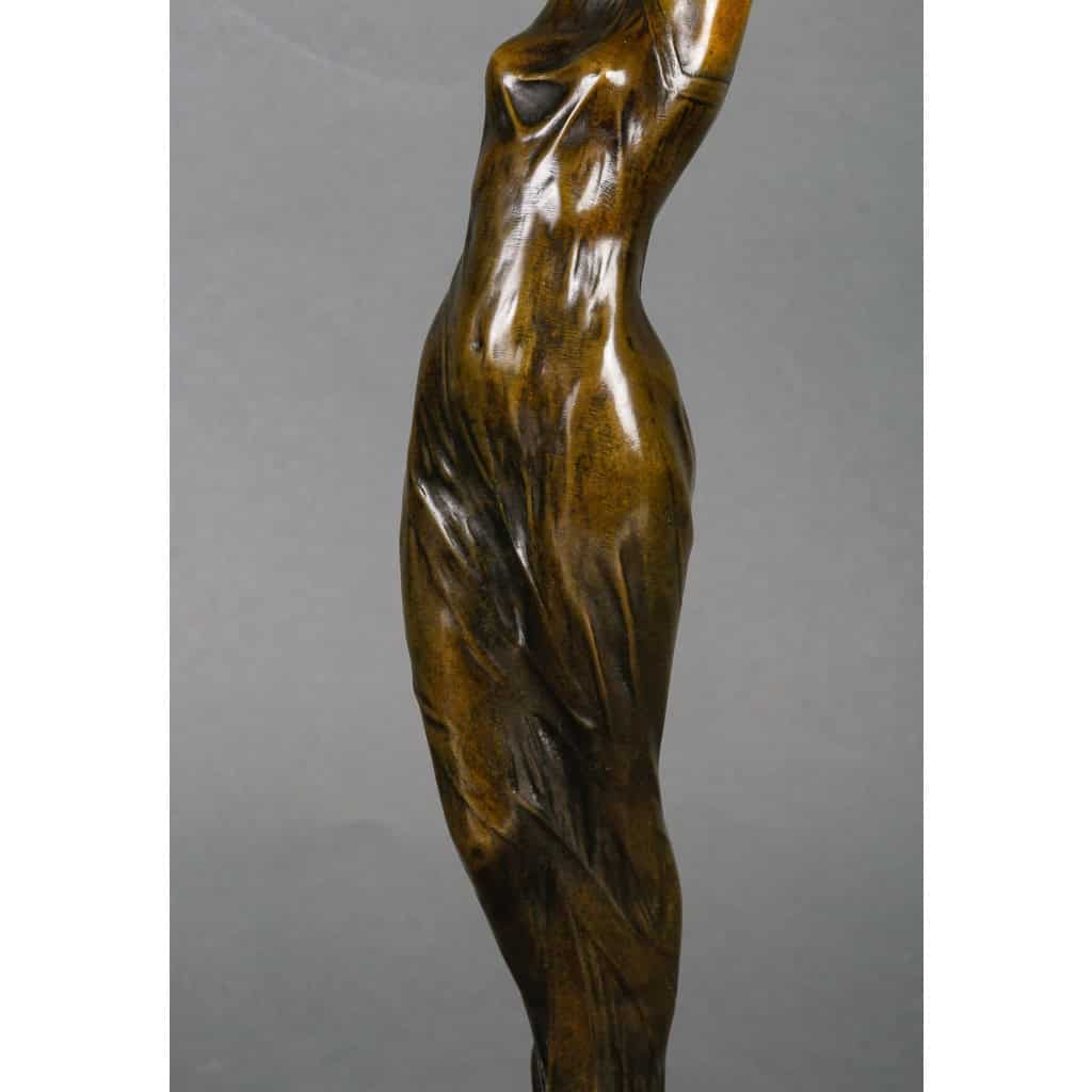 Lampe en bronze patiné représentant une femme retenant une tulipe en pâte de verre. Époque Art Nouveau vers 1900. Signée Firmin Bate Lampe en bronze patiné représentant une femme retenant une tulipe en pâte de verre. Époque Art Nouveau vers 1900. Signée Firmin Bate