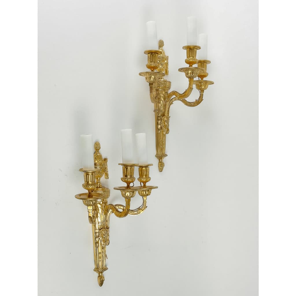 Paire d'appliques à têtes de Bélier à trois bras de lumières en bronze ciselé et doré de style Louis XVI vers 1890 Paire d'appliques à têtes de Bélier à trois bras de lumières en bronze ciselé et doré de style Louis XVI vers 1890