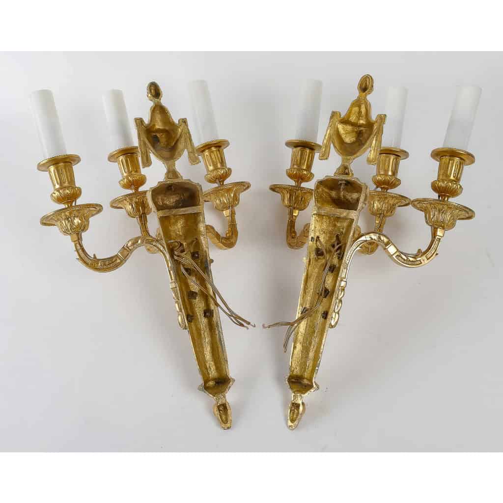 Paire d'appliques à têtes de Bélier à trois bras de lumières en bronze ciselé et doré de style Louis XVI vers 1890 Paire d'appliques à têtes de Bélier à trois bras de lumières en bronze ciselé et doré de style Louis XVI vers 1890