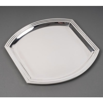 RAVINET D'ENFERT - Plat carré en argent massif époque ART DECO Plat carré en argent massif bordé de filets dont deux côtés latéraux sont incurvés Dimensions : plateau : 30 x 30,5 cm hauteur 1,5 cm Matière : Argent 1er titre 950/°°° Poids : 800 grammes env. Poinçon : MINERVE Epoque : ART DECO vers 1930 Orfèvres : RAVINET D'ENFERT Origine : France/Paris