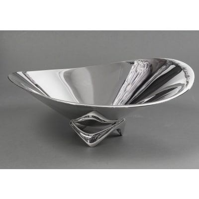 G. Jensen - H. Koppel - Centre de table en argent massif XXe Centre de table en argent massif représenté par une grande coupe hélicoïdale (en forme d’hélice) Modèle “980 A” conçue en 1948 par le designer HENNING KOPPEL (1918 - 1981) pour l’Orfèvre G. JENSEN Dimensions : La plus grande hauteur : 16 cm -La plus grande largeur 40 cm Matière : Argent 925/°°° Poids : 3703 Grammes Poinçon : HK - 925 S - B11 - GEORG JENSEN Epoque : XXè Orfèvre : GEORG JENSEN Le designer danois Henning Koppel (Copenhague 1918-1981) a d'abord étudié le dessin, puis la sculpture avec Anker Hoffmann à l'Académie royale des arts danoise à Copenhague. Il a commencé à créer de l'or et de l'argent en exil en Suède pendant la Seconde Guerre mondiale chez Orrefors et Svenskt Tenn. Il est retourné à Copenhague en 1945 et a travaillé avec l'orfèvre Georg Jensen jusqu'à sa mort en 1981. Ses créations, appelées "New Look", avaient une conception créative totalement nouvelle. S'éloignant des éléments décoratifs de l'Art nouveau et de la géométrie de l'époque Art déco, ses travaux présentent des surfaces sobres avec une forme de base légèrement asymétrique et d'apparence organique. Ses travaux ont été récompensés par des médailles d'or à la Triennale de Milan en 1951, 1954 et 1957. Lit. Janet Drucker, Georg Jensen - A Tradition of Splendid Silver, 1997, p. 252