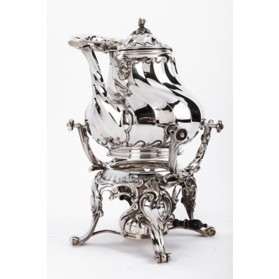 Orfèvre MARTIN Marie Vve - Samovar rocaille en argent massif XIXe Samovar en argent composé d'un support à quatre pieds à enroulement soutenant un bruleur manche ébène surmonté d' une importante verseuse à côtes torses décorée de vagues et de feuillage. anse et bec verseur torsadés Dimensions : hauteur 33 cm - hauteur totale avec anse 40 cm diametre : 24 cm Poids : 2045 grammes Matière : argent Poinçon : Minerve Epoque : XIXè Orfèvre ; MARTIN Marie Vve 1886 ( une cloche une étoile) Origine : France